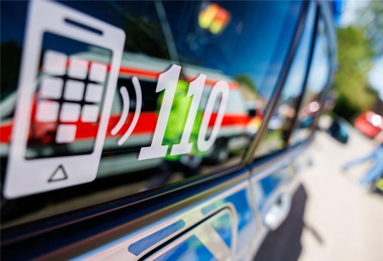 Eigenen Vater angezündet: Mann in Hamburg bei SEK-Einsatz erschossen Die Nummer des Polizeinotrufs 110 steht auf der Scheibe eines Polizeifahrzeugs, in der sich ein Fahrzeug vom Roten Kreuz spiegelt.