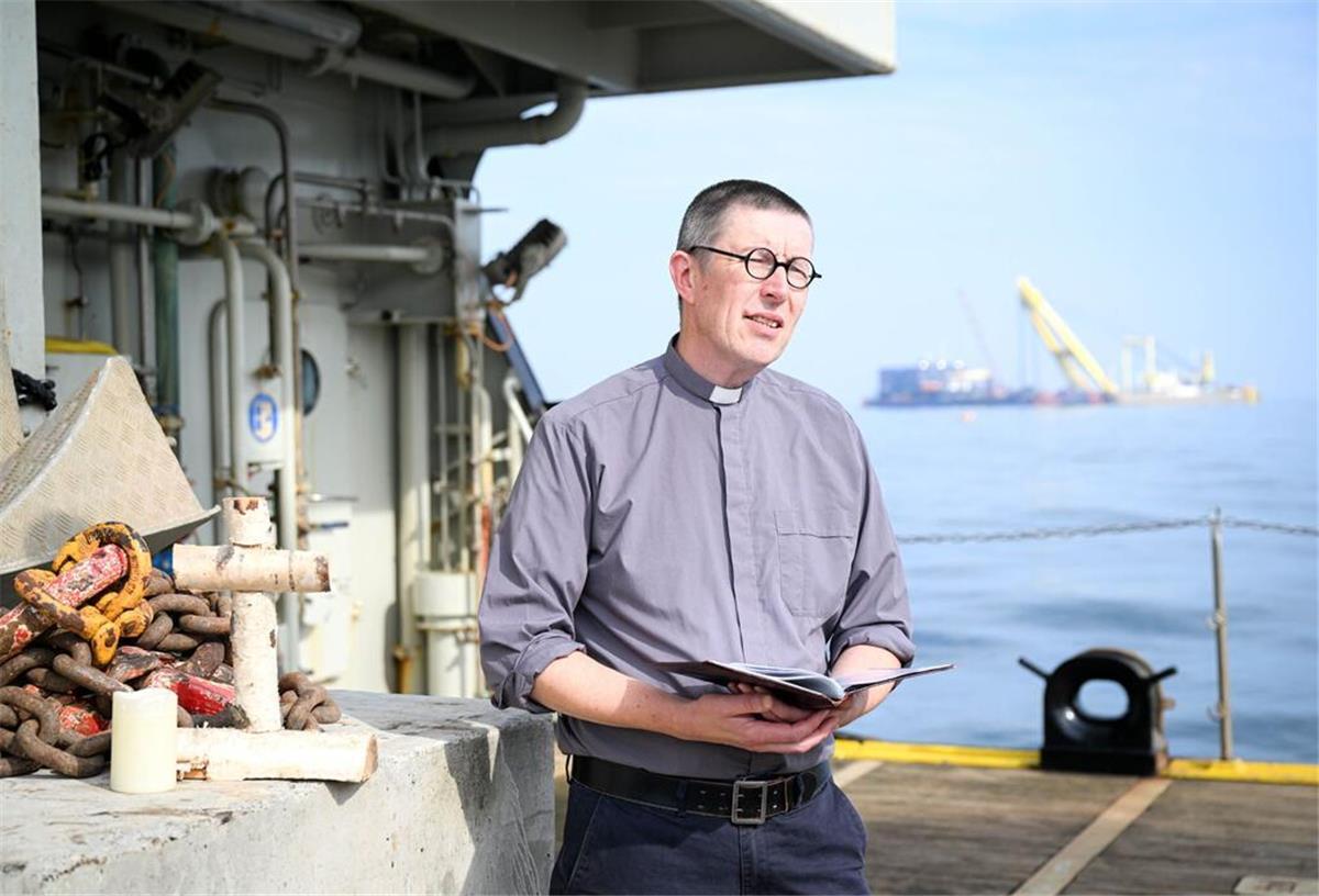 Bei einer Andacht in der Nähe des Wracks des gesunkenen Frachters „Verity“ erinnert Diakon Martin Struwe an die Toten und Vermissten.