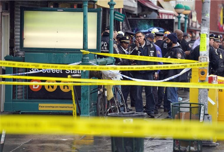 Schüsse in der New Yorker U-Bahn: Verdächtiger festgenommen (62) Mitarbeiter des New York City Police Department versammeln sich am Eingang einer U-Bahn-Station im New Yorker Stadtteil Brooklyn.