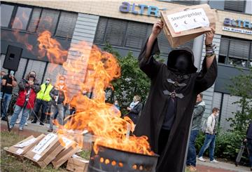 Bei einer Protestkundgebung der IG Metall in Bremen schmeißt ein Mann vor dem Airbus-Werk eine Tüte in eine Feuertonne.