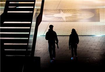  Zwei junge Menschen gehen am Abend mit Flaschen in den Händen kurz vor Beginn der Ausgangsbeschränkungen zur Eindämmung der Corona-Pandemie durch die Innenstadt. 
