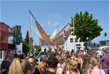 Menschen auf einer Straße mit Bungee-Trampolin im Hintergrund