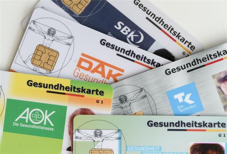 Rückzahlung des Krankenkassenbeitrags? Bei diesen Anrufen solltet ihr aufpassen! Gesundheitskarten verschiedener Krankenkassen liegen auf einem Tisch.