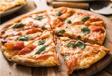 Ein Pizza liegt geschnitten auf einem Holzbrett. Bei „Moto 59“ gibt es Pizza, Pasta und Burger im Rennsport-Ambiente. Doch das Konzept scheint nicht überall zu funktionieren.