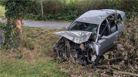 ein beschädigtes Auto steht nach einem Unfall teilweise in einem Graben
