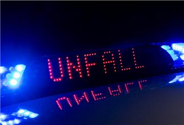 Das Blaulicht auf einem Fahrzeug der Polizei leuchtet in der Dunkelheit, während auf dem Display der Hinweis «Unfall» zu lesen ist.