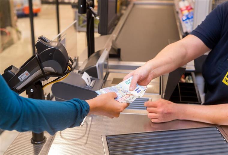 Bargeld an der Supermarkt-Kasse: Klingt gut, aber die Nachteile überraschen In einem Supermarkt hebt eine Kundin beim Bezahlen auch gleich Bargeld ab.