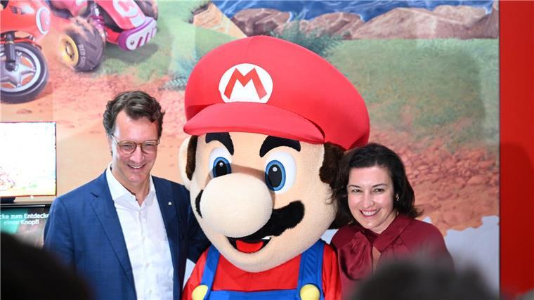 Beim Messerundgang über die Gamescom kam der Tross von Politikern auch beim Messestand von Nintendo vorbei, hier stehen NRW-Ministerpräsident Hendrik Wüst (CDU) und Bundesforschungsministerin Dorothee Bär (CSU) neben einer Mario-Plüschfigur.