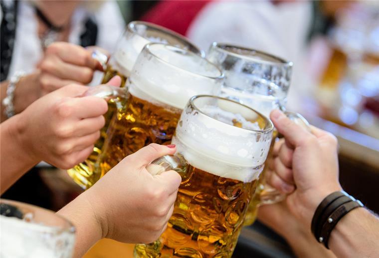 Oktoberfest in Stotel: Vorverkauf nicht verpassen Menschen prosten sich mit ihrer ersten Maß Bier zu.