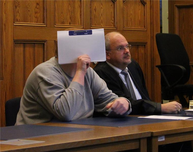 Prozess in Stade: Cuxhavener soll Jungen missbraucht haben Beim Prozessauftakt im Stader Landgericht verdeckt der Angeklagte aus Cuxhaven sein Gesicht mit einer Akte. Rechts neben ihm hat sein Verteidiger, der Cuxhavener Rechtsanwalt Andreas Meyn, Platz genommen.
