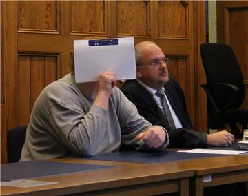 Beim Prozessauftakt im Stader Landgericht verdeckt der Angeklagte aus Cuxhaven sein Gesicht mit einer Akte. Rechts neben ihm hat sein Verteidiger, der Cuxhavener Rechtsanwalt Andreas Meyn, Platz genommen.