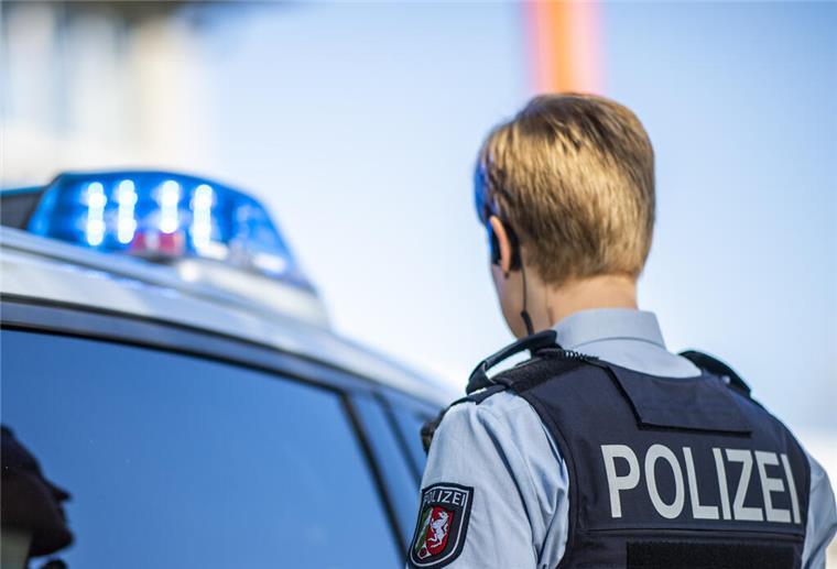 56-Jähriger stirbt bei Arbeitsunfall auf Bremer Recyclinghof Eine Polizistin steht vor einem Streifenwagen, dessen Blaulicht leuchtet