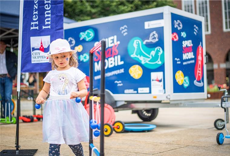 Bremerhaven: Spielmobil soll Innenstadt beleben Beim Start des Spiel- und Spaßmobils für Kinder in der Bremerhavener Fußängerzone probiert Emma (5) die mobilen Spielsachen aus.