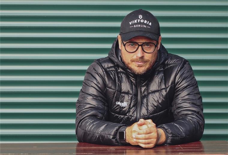 Bremerhavener Muzzicato muss Viktoria Berlin verlassen Mann mit schwarzer Jacke und Cappy vor einer grünen Wand. Benedetto Muzzicato hat seinen Job in Berlin verloren.