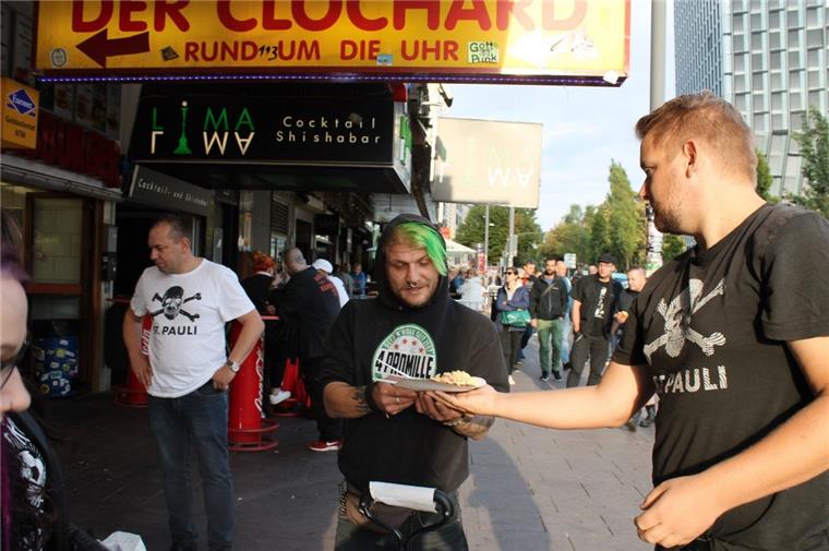 Zevener kümmern sich um Obdachlose in Hamburg Benjamin Haxel (rechts) verteilt auf der Reeperbahn in Hamburg Schnitzel mit Nudelsalat an bedürftige Menschen.