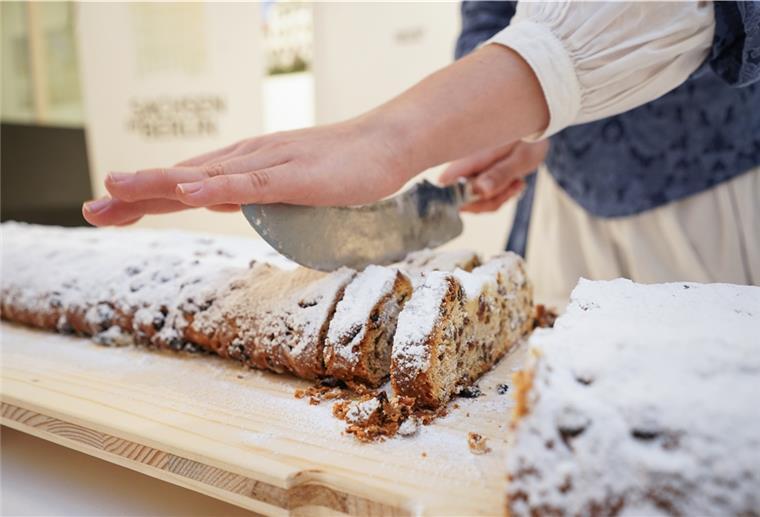 Lebensmittelindustrie: NGG fordert bis zu 6,5 Prozent mehr Geld Eine Frau schneidet einen Stollen an.