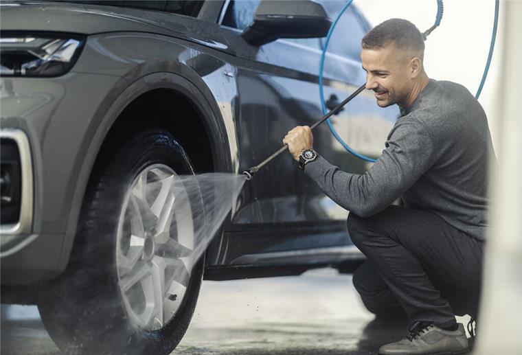 Ein Mann reinigt die Reifen eines Autos. Besonders nach dem Winter ist es wichtig, das Auto richtig zu pflegen. In nur 7 Schritten gelingt der Frühjahrsputz fürs Auto. 