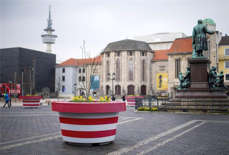 Bunt statt grau: So könnten die Monsterkübel Bremerhaven schöner machen Ein rot-weiß gestreifter Kübel ist auf einem öffentlichen Platz zu sehen.