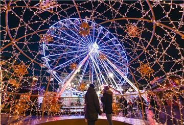 Auf dem Bremerhavener Weihnachtsmarkt dreht sich das leuchtende Riesenrad im Dunkeln.