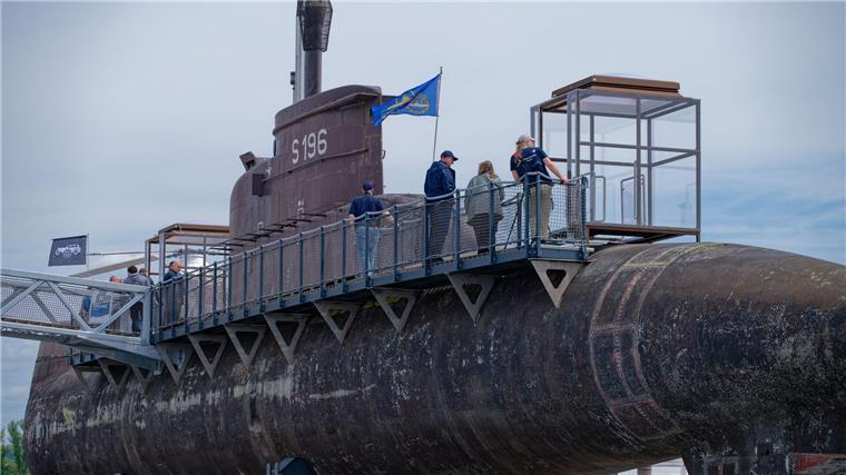 Ein U-Boot zum Staunen und Hören: U17 ist nun zugänglich Besucher gehen über einen Steg am Marine U-Boot U17 entlang.