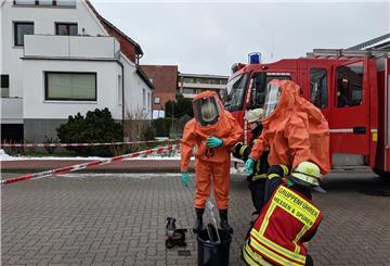 Bevor sie in das Haus gingen, legten die Feuerwehrleute ihre Schutzanzüge an.