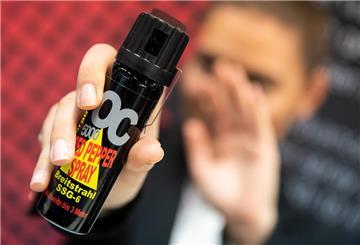 Eine Frau hält Pfefferspray in der Hand