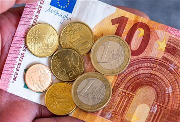 Geldscheine und Euromünzen. (zu dpa: «Studie: Ostdeutsche profitieren besonders vom Mindestlohn»)