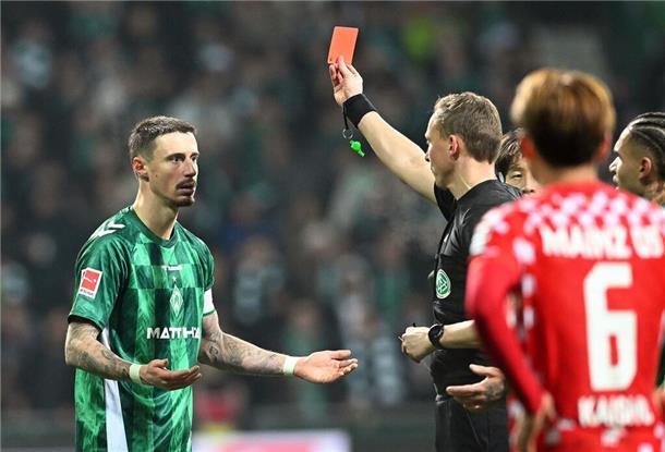 Fußball: Bundesliga, Werder Bremen - FSV Mainz 05, 20. Spieltag, Weserstadion. Schiedsrichter Martin Petersen (M) zeigt Werders Marco Friedl (l) die gelb-rote Karte. (zu dpa: ««Eine Sechs minus»: Wie ein Werder-Sieg am Ende eskaliert»