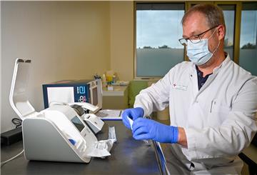 Bildtext für Bildcombo: Labormediziner Dr. Bernd Wolters zeigt das kleinere Gerät für die schnelle PCR-Test-Variante. Auch dafür muss ein Rachenabstrich genommen werden. Der PCR-Test kann auch geringe Virusmengen nachweisen. Das kann der Antigentest, der an einen Schwangerschaftstest erinnert, nicht so zuverlässig.