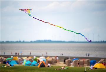 Ein Drache fliegt bei windigen Wetter über den Strand