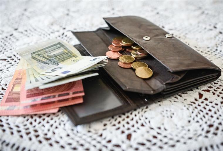 Merz-Regierung streicht zugesagte 200-Euro-Hilfe! Millionen Bürger betroffen Eine Geldbörse liegt auf einem Tisch.