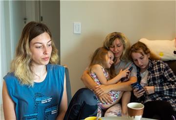 Zwei aus der Ukraine geflüchtete Frauen und zwei Kinder halten sich in einem Raum einer Flüchtlingsunterkunft auf.