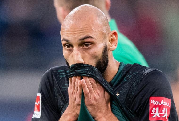 Werder-Verteidiger Ömer Toprak schon wieder verletzt Mann ist traurig, hält sich ein Trikot vor den Mund