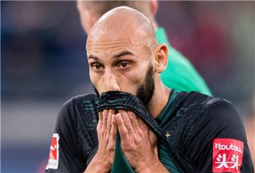 Mann ist traurig, hält sich ein Trikot vor den Mund