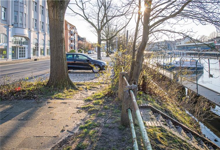 Promenade contra Parkplatz Blick auf die Kaistraße Bremerhaven mit Bootsanlegestelle und Parkplätzen neben Wohn- und Geschäftsgebäuden.