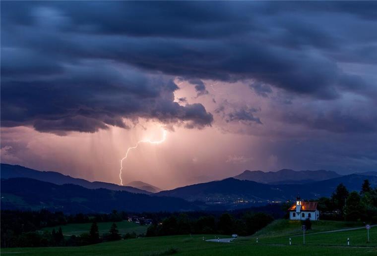 Wetterdienst sagt schwere Unwetter voraus: Hier soll es besonders heftig werden Blitze entladen sich über den Alpen während eines aufziehenden Gewitters. Blitze, Donner, Regen: Der Deutsche Wetterdienst (DWD) sagt schwere Unwetter voraus.