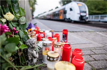 Blumen und Kerzen stehen  am Bahnsteig. Eine Frau wird in Voerde völlig unvermittelt vor einen einfahrenden Zug gestoßen. Sie wird überrollt und stirbt. Jetzt beginnt die juristische Aufarbeitung.