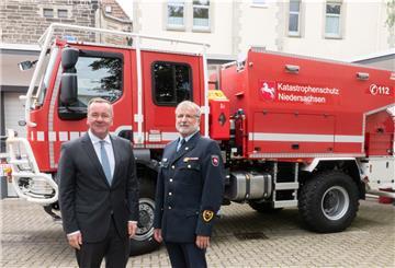 Boris Pistorius (SPD, l) und Landesbranddirektor Jörg Schallhorn stehen vor einem neuen Einsatzfahrzeug der Feuerwehr Niedersachsen.
