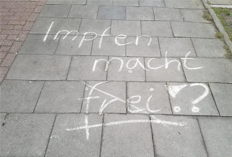 Cuxhaven: Querdenker beschmieren Fußweg mit Anti-Impf-Parolen "Impfen macht frei" steht mit Kreide geschrieben auf einem Gehweg.