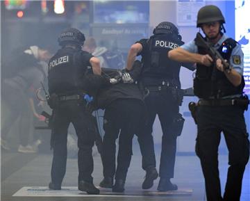 Zwei Polizisten ziehen einen fiktiven Attentäter aus dem Hauptbahnhof