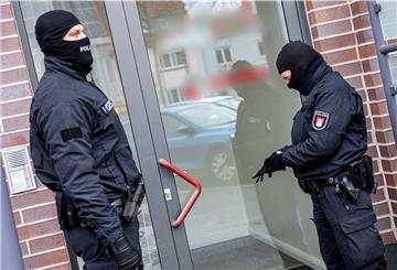 Bremer Polizisten stehen bei ihrem Großeinsatz im kriminellen Milieu vor einem Gebäude in Hemelingen.