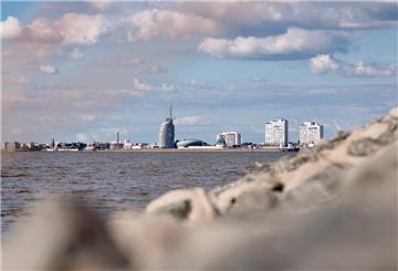 Blick auf die Weser und die Skyline von Bremerhaven mit der Sail City Aussichtsplattform, dem Klimahaus und Apartmentgebäuden.