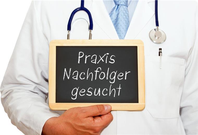 Bremerhaven: Wie man jetzt dringend neue Ärzte gewinnt Ein Mann im Arztkittel hält ein Schild in der Hand.