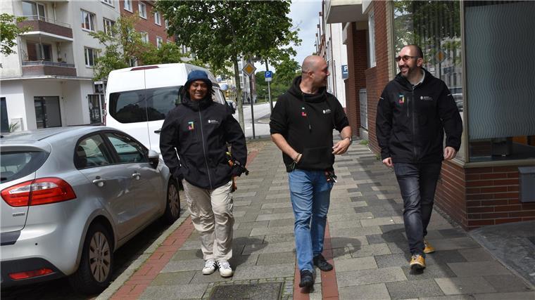 Bremerhavens Streetworker sind an sozialen Brennpunkten im Einsatz Drei Männer laufen nebeneinander auf dem Gehsteig und unterhalten sich dabei