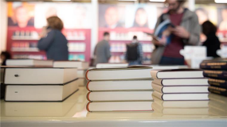 Buchmesse: Jubiläum zwischen Tradition und Moderne Bücher liegen auf der Frankfurter Buchmesse an einem Stand. Die Frankfurter Buchmesse feiert ihr 75. Jubiläum.
