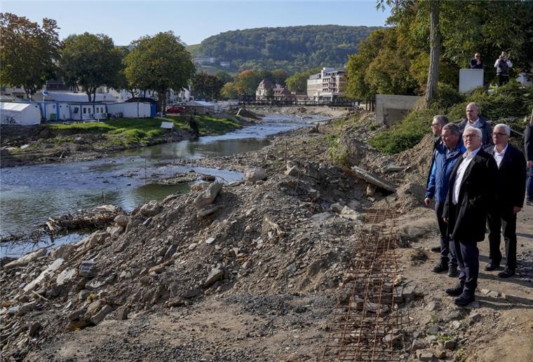 Studie: Klimawandel kostet in Deutschland jährlich 6,6 Milliarden Bundespräsident Frank-Walter Steinmeier (vorne) steht am Ufer der Ahr, Der Bundespräsident war 2021 ins Ahrtal gereist, um sich erstmals persönlich einen Eindruck von den Schäden der Flutkatastrophe und dem Wiederaufbau zu machen. Solche Extremwetterereignisse kommen immer häufiger vor und kosten sehr viel Geld.