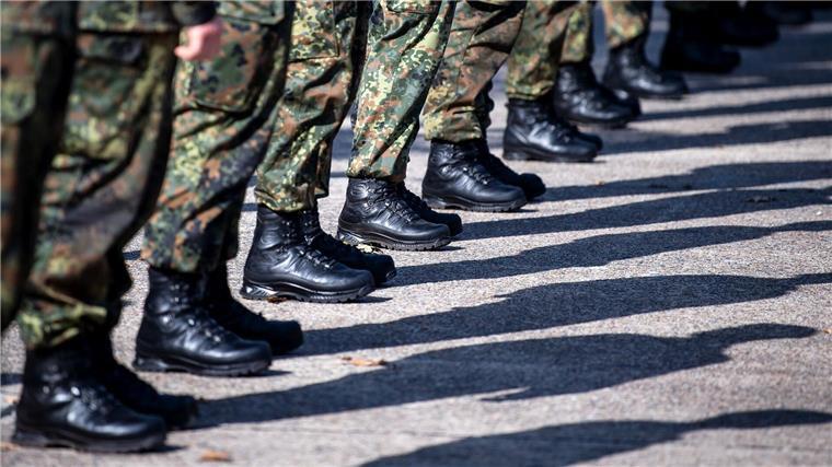 Bundeswehr-Kolonne unterwegs Richtung Osten Bundeswehrsoldaten stehen auf einem Platz.