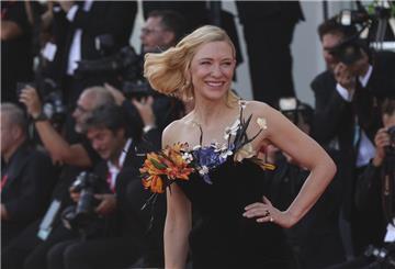 Die Schauspielerin Cate Blanchett lächelt auf einem roten Teppich und wird fotografiert.