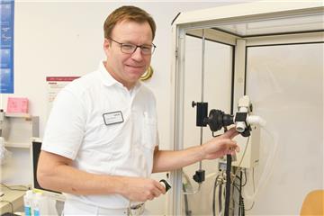 Chefarzt Dr. Hans Jörg Baumann demonstriert im Ameos-Klinikum Am Bürgerpark ein medizinisches Gerät zur Messung der Lungenfunktion.