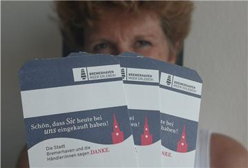 City-Managerin Claudia Bitti zeigt, wie eine Treue-Aktion der Innenstadt-Händler aussieht.